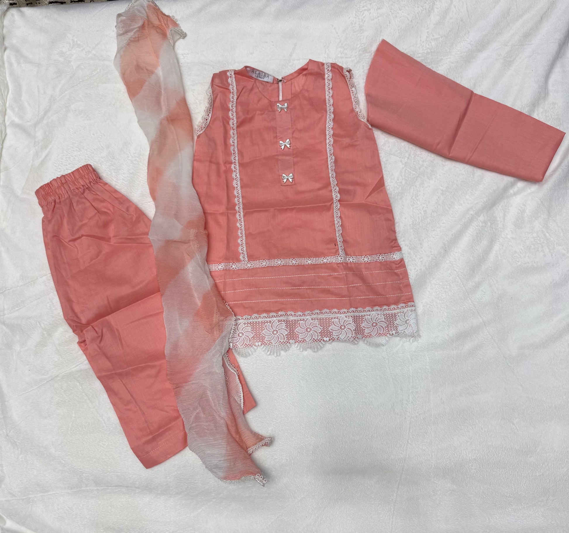 Close-up of delicate lace and bow detailing on Peach Lace Baby Girl Kurta Set With Dupatta - Pakistani baby clothes UK
